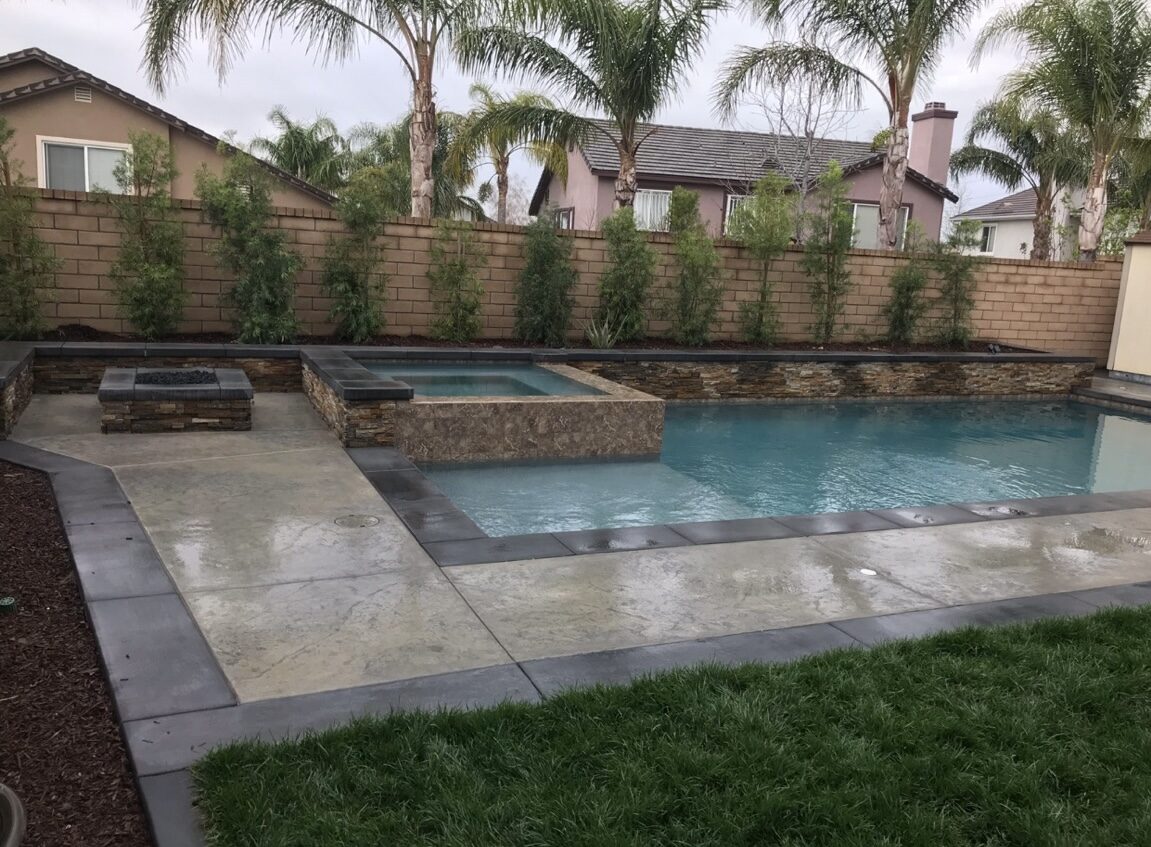 Pool and raised spa with fire pit and stamped concrete decking